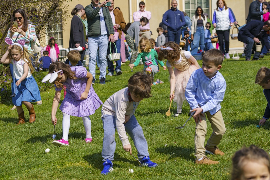 Children look for easter eggs on the lawn of Tudor Place.
