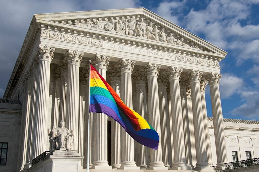 An LGBTQ+ flag flies in front of the Supreme Court.